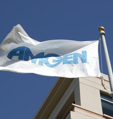 Amgen-vlag wapperend tegen een gebouw en een blauwe lucht.