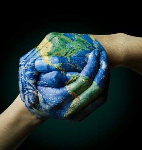 Handen geschilderd als een globe en die elkaar vastgrijpen.